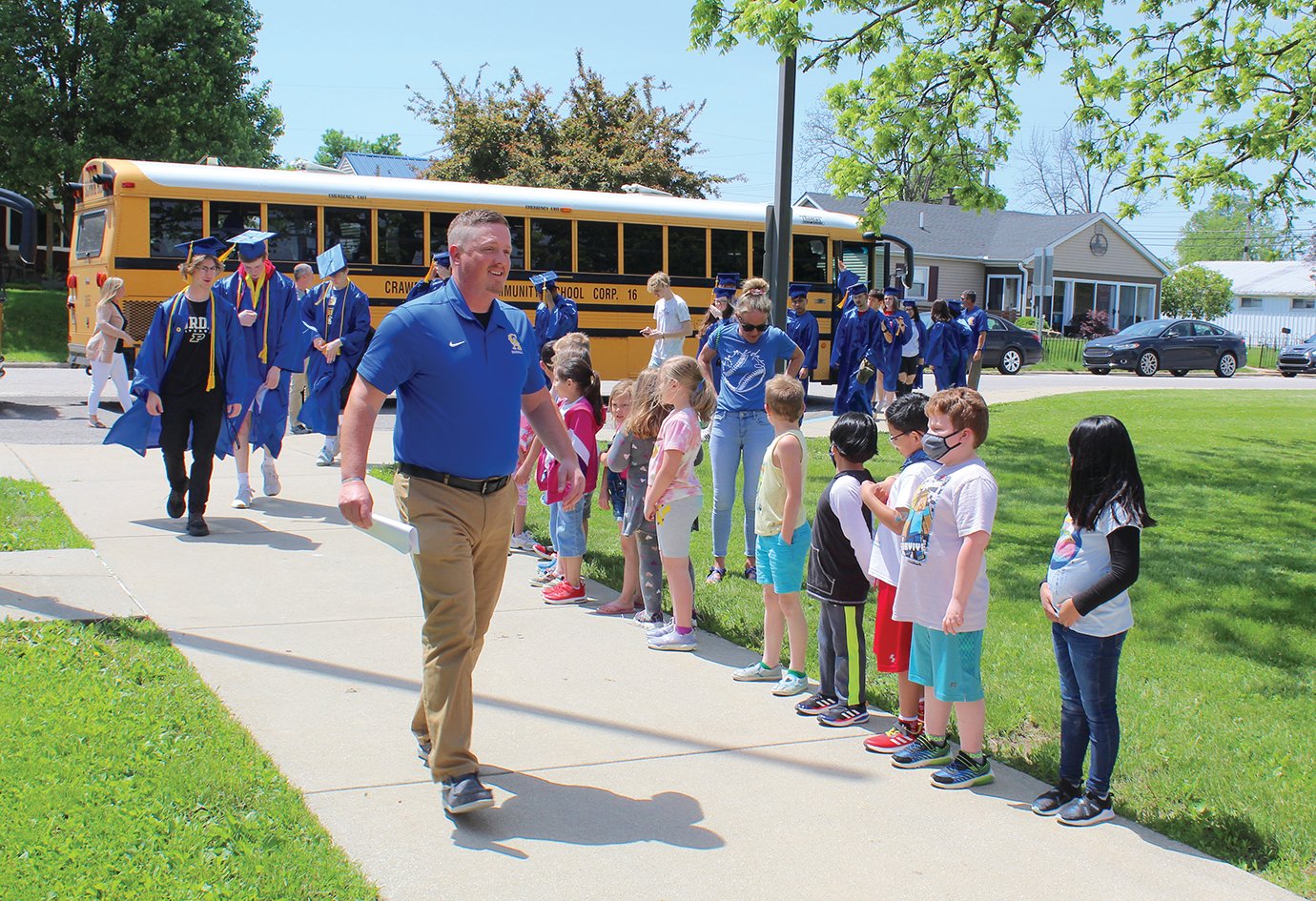 Crawfordsville High School Principal Jay Strickland leads the 2022 graduating class Tuesday on a Senior Walk at Hose Elementary. The seniors marched through Hose, Nicholson and Hoover elementary schools.